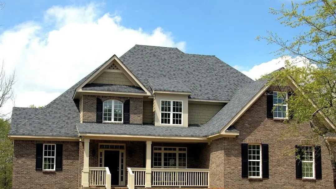 Two-story brick home with a new gray asphalt shingle roof